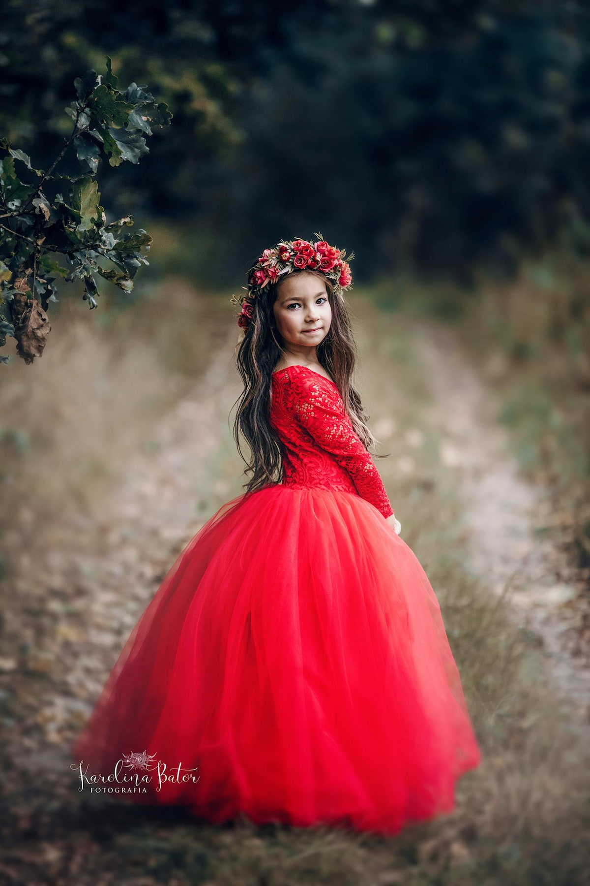 Child in a long sleeve lace and tulle dress posing outdoors in nature