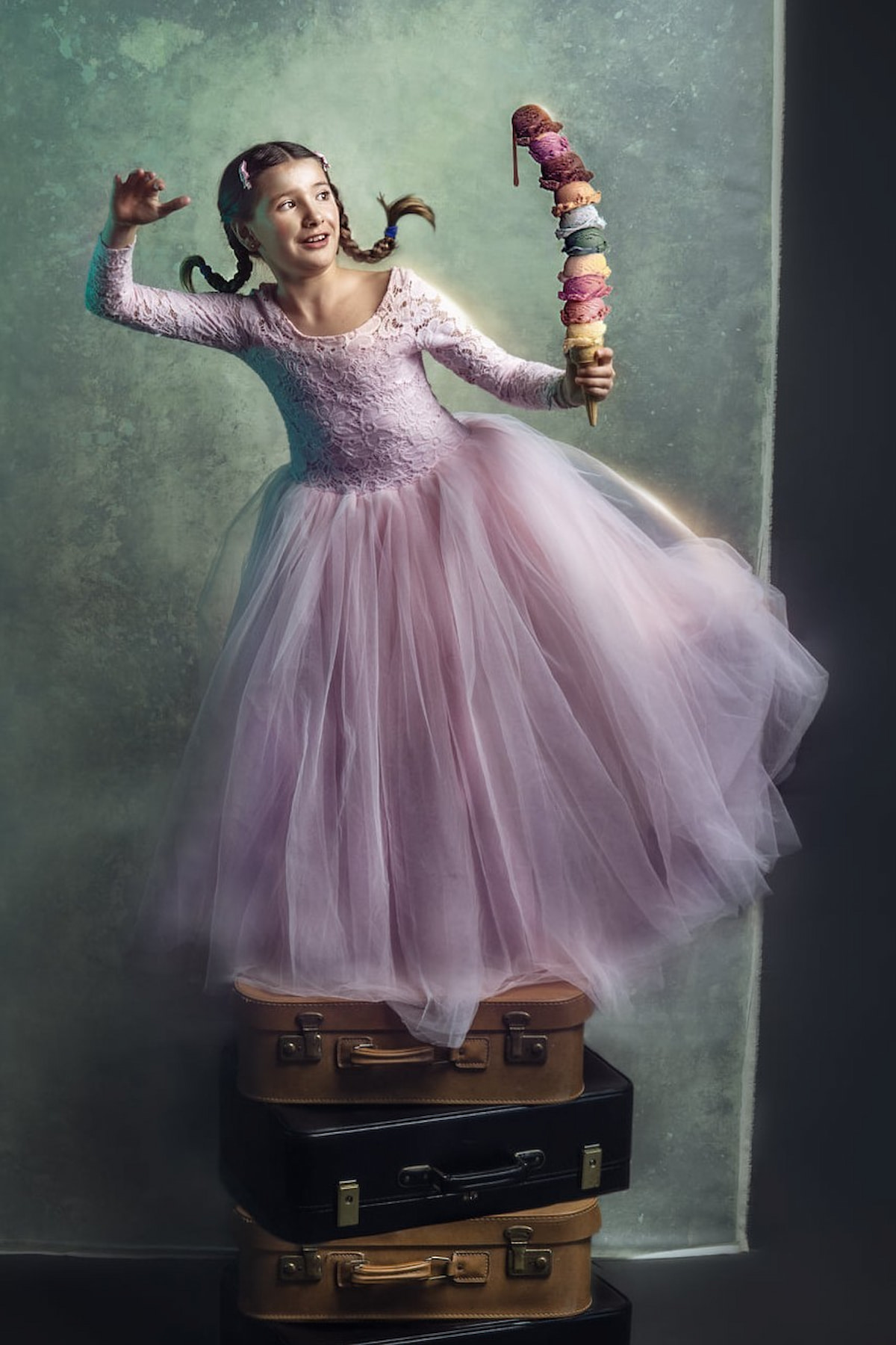 Child in a long tulle gown holding a large ice cream prop during a styled shoot