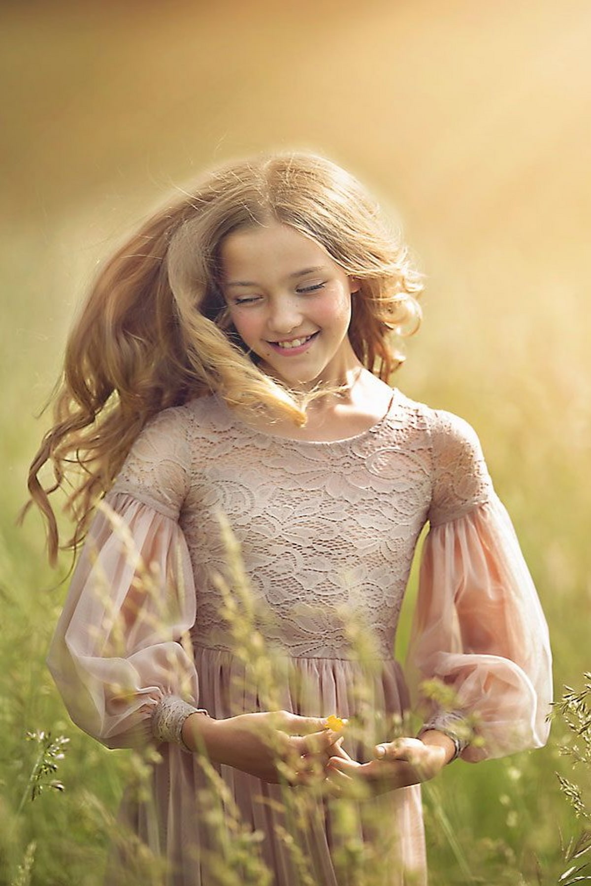 Girl in a lace dress surrounded by greenery in a dreamy outdoor photoshoot