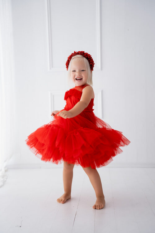 Child wearing a layered tulle dress spinning on a white background
