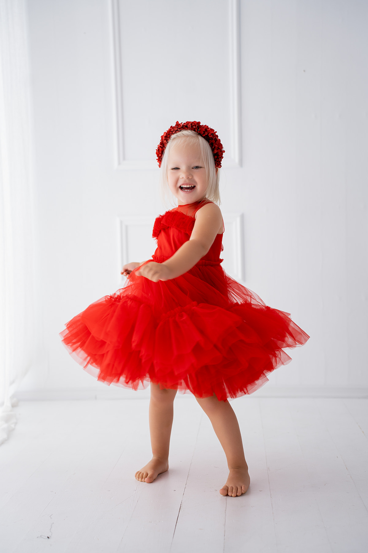 Child wearing a layered tulle dress spinning on a white background