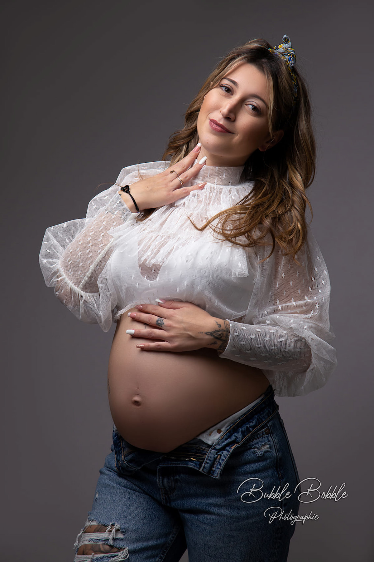 Fine art maternity portrait with transparent dotted tulle top
