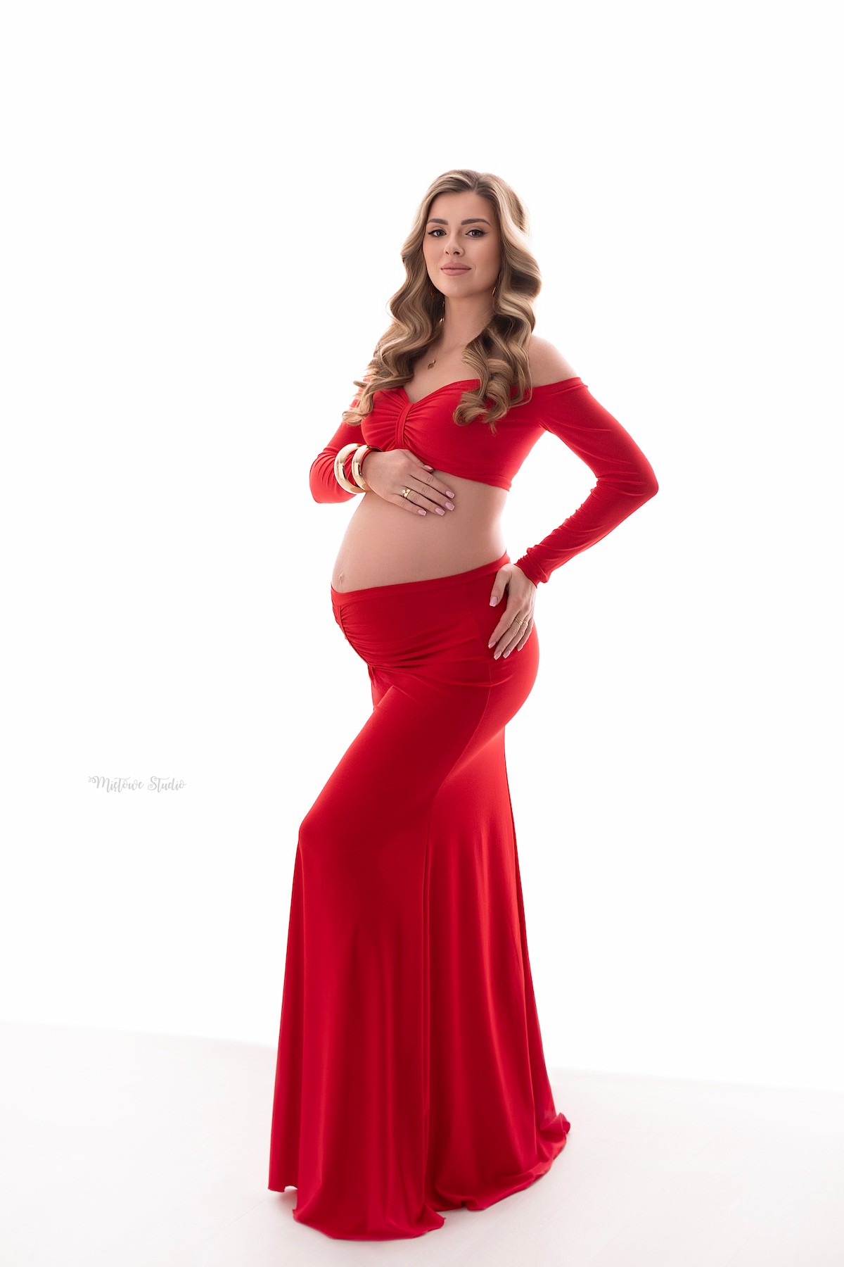 Close-up of red maternity set with front ruching emphasizing pregnancy silhouette