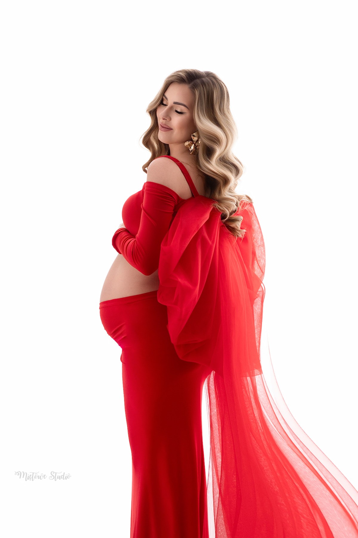 Elegant maternity look with statement bow veil accessory in red tulle